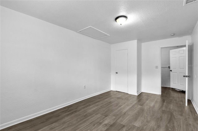 1116 Jadewood Ave, Clearwater, FL 33759 - unfurnished bedroom featuring attic access, dark wood finished floors, a textured ceiling, and a closet