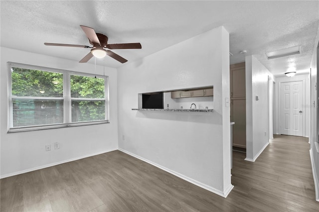 1116 Jadewood Ave, Clearwater, FL 33759 - unfurnished living room featuring attic access, a textured ceiling, a ceiling fan, and wood finished floors