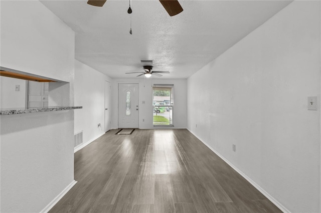 1116 Jadewood Ave, Clearwater, FL 33759 - unfurnished living room with a ceiling fan, wood finished floors, and a textured ceiling