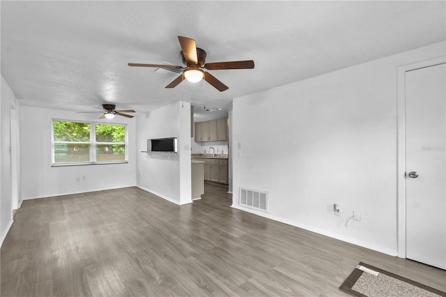 1116 Jadewood Ave, Clearwater, FL 33759 - unfurnished living room featuring dark wood-style flooring, a ceiling fan, and a textured ceiling