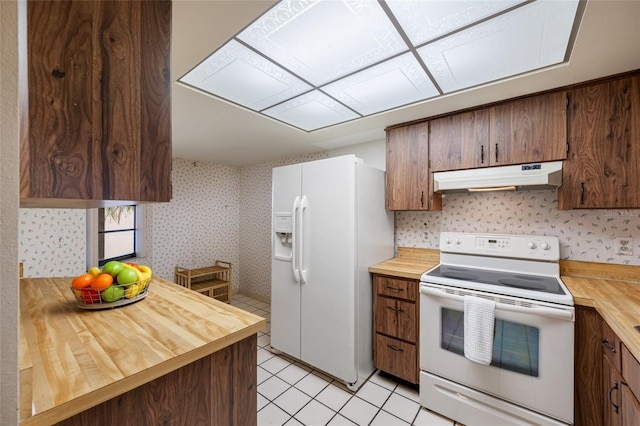 2131 Ridge Rd S Unit 19, Largo, FL 33778 - kitchen with white appliances, under cabinet range hood, butcher block countertops, light tile patterned floors, and wallpapered walls