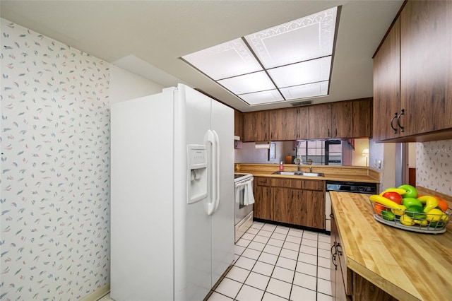 2131 Ridge Rd S Unit 19, Largo, FL 33778 - kitchen featuring white appliances, butcher block countertops, light tile patterned floors, and wallpapered walls