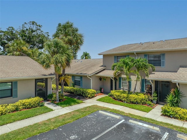 2131 Ridge Rd S Unit 19, Largo, FL 33778 - view of front of home with stucco siding, uncovered parking, and a shingled roof
