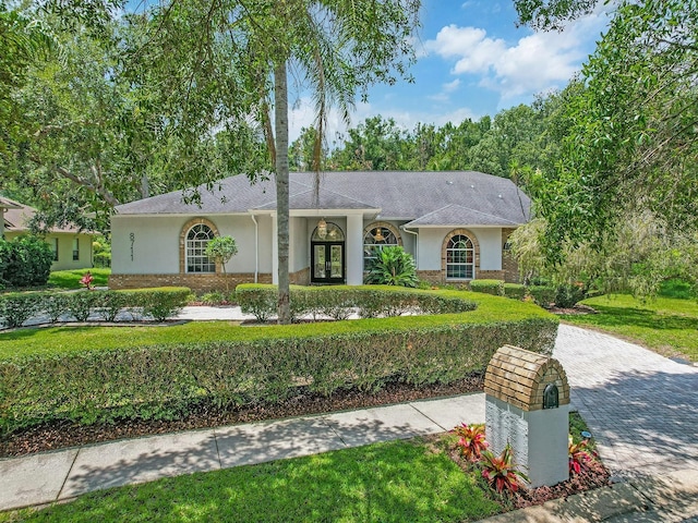 8711 Crescent Forest Blvd, New Port Richey, FL 34654 - ranch-style home with stucco siding, french doors, and a front lawn
