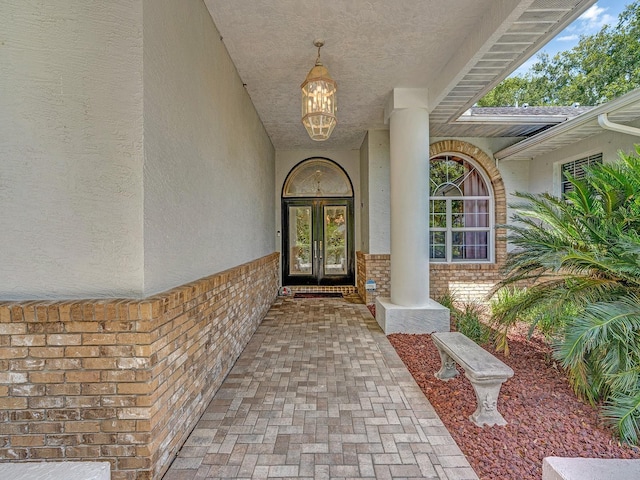 8711 Crescent Forest Blvd, New Port Richey, FL 34654 - view of exterior entry featuring stucco siding, brick siding, and french doors