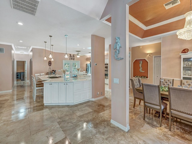 8711 Crescent Forest Blvd, New Port Richey, FL 34654 - kitchen featuring white cabinetry, ornamental molding, light countertops, pendant lighting, and a ceiling fan