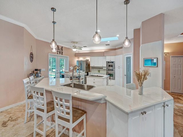 8711 Crescent Forest Blvd, New Port Richey, FL 34654 - kitchen featuring a large island, white cabinets, crown molding, stainless steel appliances, and french doors