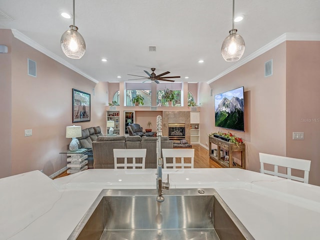 8711 Crescent Forest Blvd, New Port Richey, FL 34654 - dining space with ceiling fan, crown molding, a fireplace, recessed lighting, and wood finished floors
