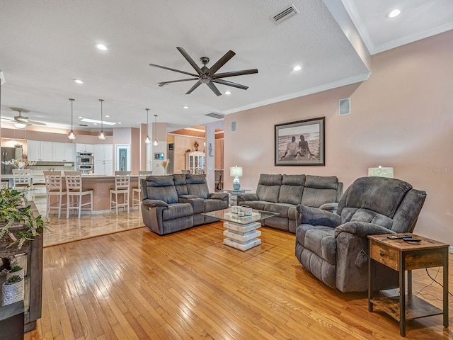 8711 Crescent Forest Blvd, New Port Richey, FL 34654 - living room featuring ceiling fan, light wood finished floors, recessed lighting, and ornamental molding