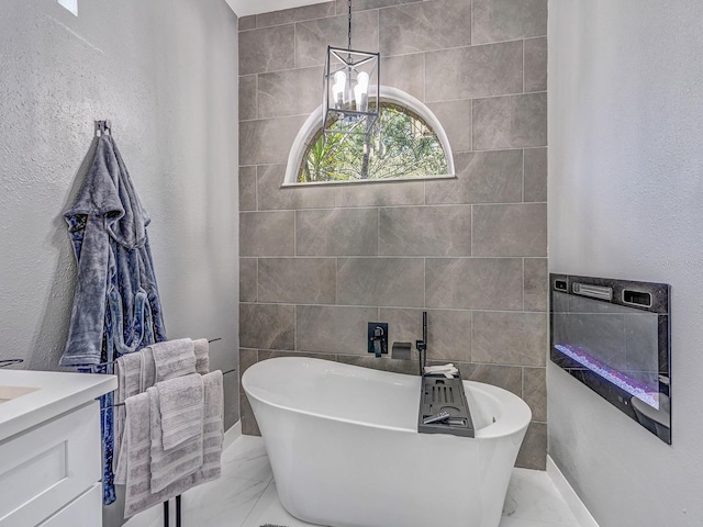 8711 Crescent Forest Blvd, New Port Richey, FL 34654 - full bathroom featuring marble finish flooring, a freestanding bath, vanity, and a textured wall