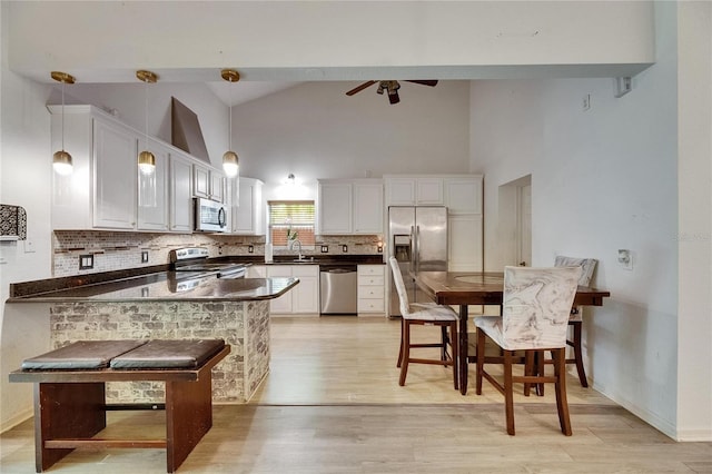 9041 58th St N, Pinellas Park, FL 33782 - kitchen with appliances with stainless steel finishes, dark countertops, high vaulted ceiling, ceiling fan, and white cabinets