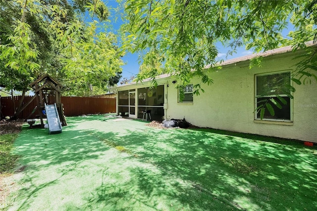 9041 58th St N, Pinellas Park, FL 33782 - fenced backyard with a sunroom and a playground