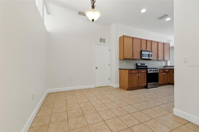 5390 Greystone Dr, Spring Hill, FL 34609 - kitchen featuring stainless steel appliances, dark countertops, tasteful backsplash, light tile patterned floors, and brown cabinets