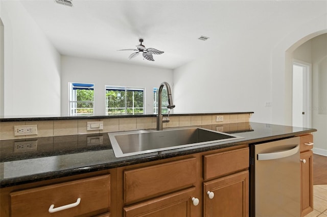 5390 Greystone Dr, Spring Hill, FL 34609 - kitchen featuring stainless steel dishwasher, tasteful backsplash, arched walkways, brown cabinetry, and ceiling fan