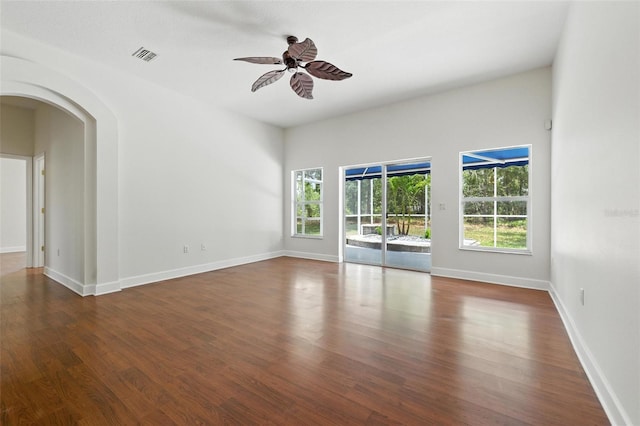 5390 Greystone Dr, Spring Hill, FL 34609 - spare room featuring wood finished floors, arched walkways, and a ceiling fan