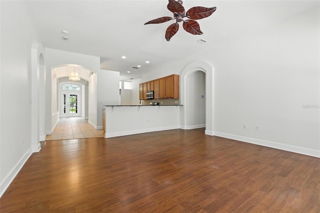 5390 Greystone Dr, Spring Hill, FL 34609 - unfurnished living room featuring arched walkways, ceiling fan, wood finished floors, and recessed lighting
