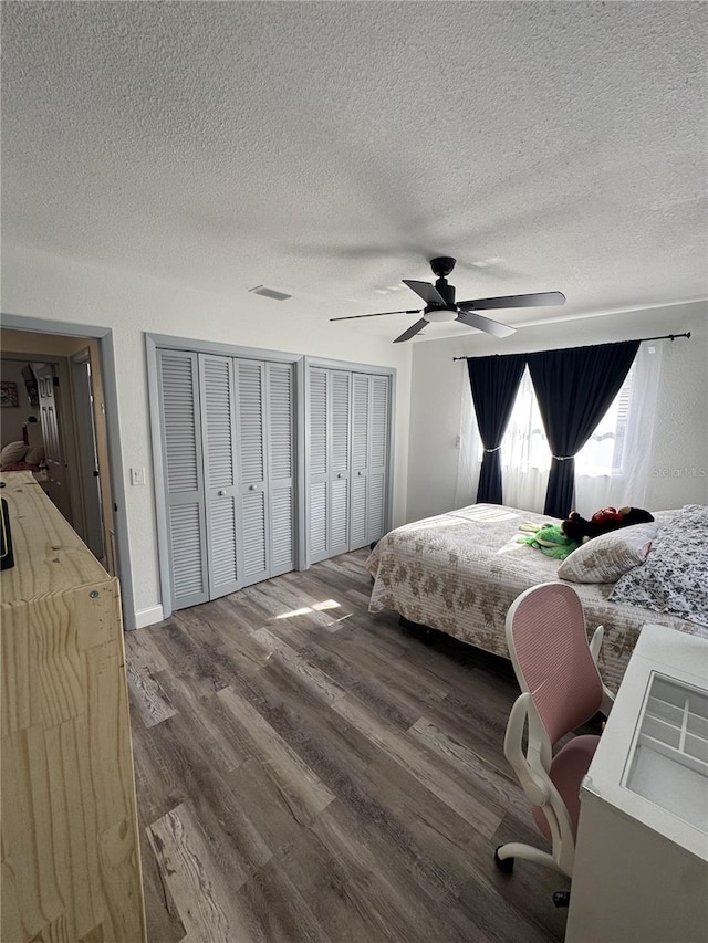 2509 Thornbrook Pl, Tampa, FL 33618 - bedroom with a textured ceiling, wood finished floors, multiple closets, and a ceiling fan