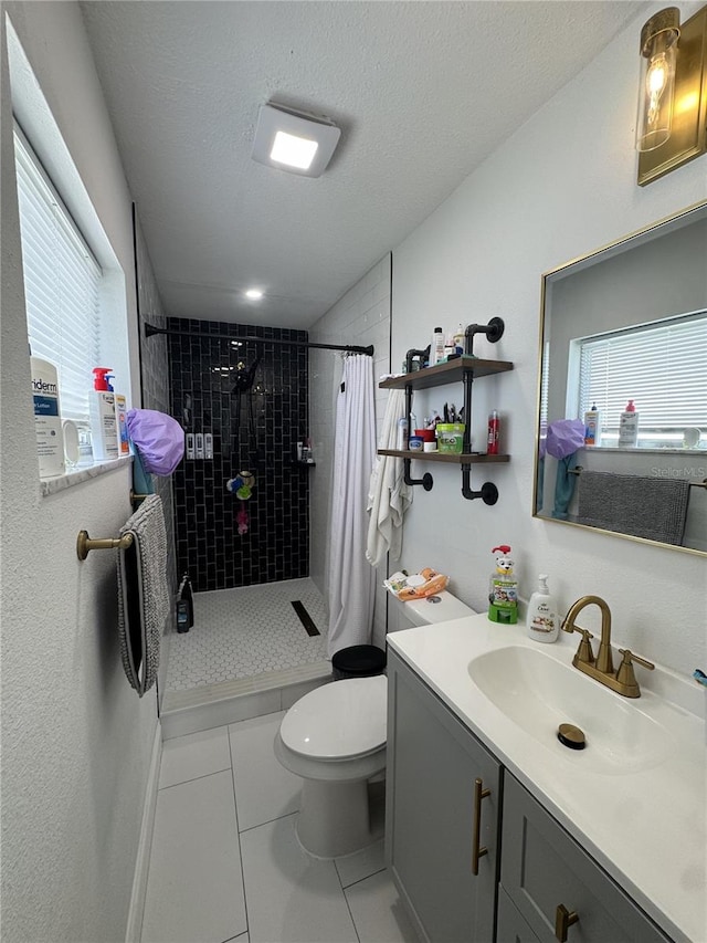 2509 Thornbrook Pl, Tampa, FL 33618 - bathroom with a tile shower, tile patterned floors, vanity, and a textured ceiling