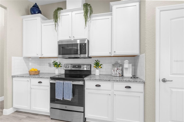 12333 Harris Hawk Rd, Weeki Wachee, FL 34614 - kitchen with appliances with stainless steel finishes, tasteful backsplash, and white cabinets