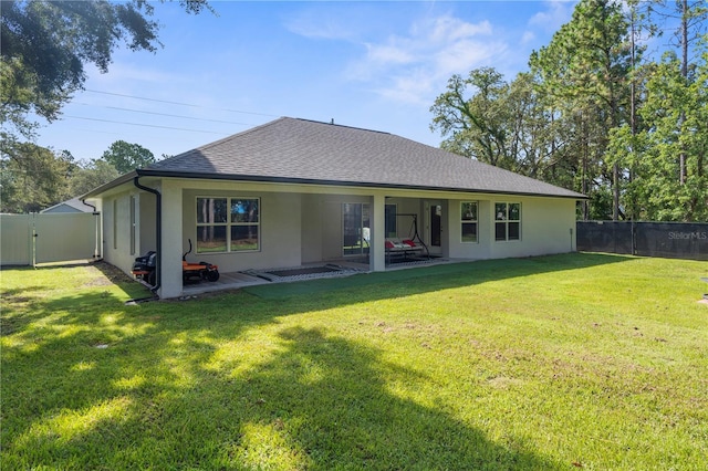 12333 Harris Hawk Rd, Weeki Wachee, FL 34614 - back of property featuring stucco siding, a shingled roof, a fenced backyard, and a patio area