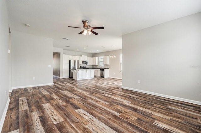 12322 Eagle Swoop Pl, Riverview, FL 33579 - unfurnished living room with dark wood-style flooring, ceiling fan, and a chandelier