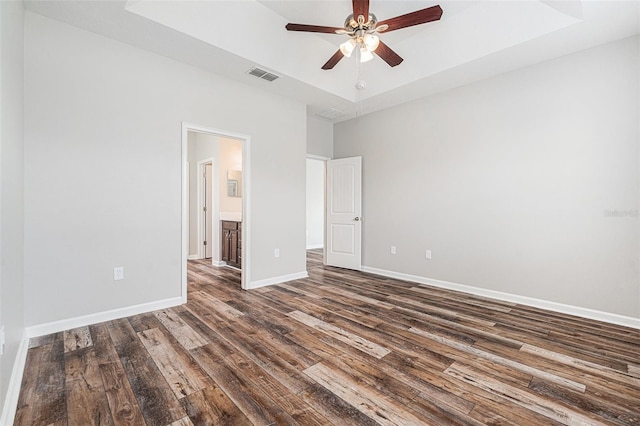 12322 Eagle Swoop Pl, Riverview, FL 33579 - unfurnished bedroom featuring a tray ceiling, dark wood-type flooring, and a ceiling fan