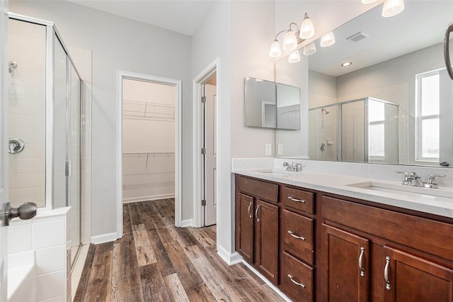 12322 Eagle Swoop Pl, Riverview, FL 33579 - full bath with a stall shower, wood finished floors, a walk in closet, and double vanity