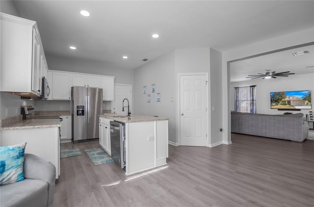 3921 SW 51st Ter, Ocala, FL 34474 - kitchen featuring appliances with stainless steel finishes, open floor plan, wood finished floors, white cabinetry, and recessed lighting