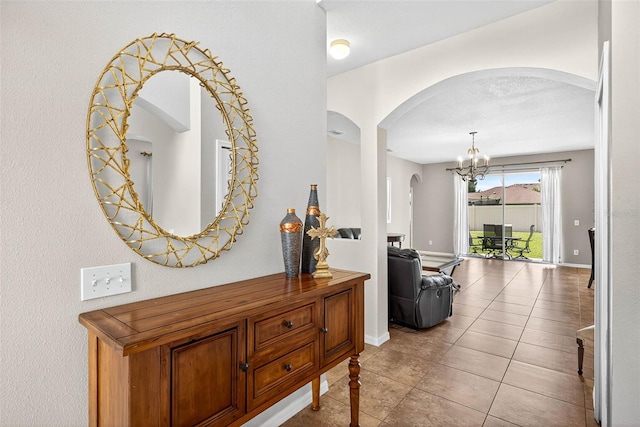 19028 Narimore Dr, Land O Lakes, FL 34638 - hallway featuring arched walkways, a chandelier, and light tile patterned floors