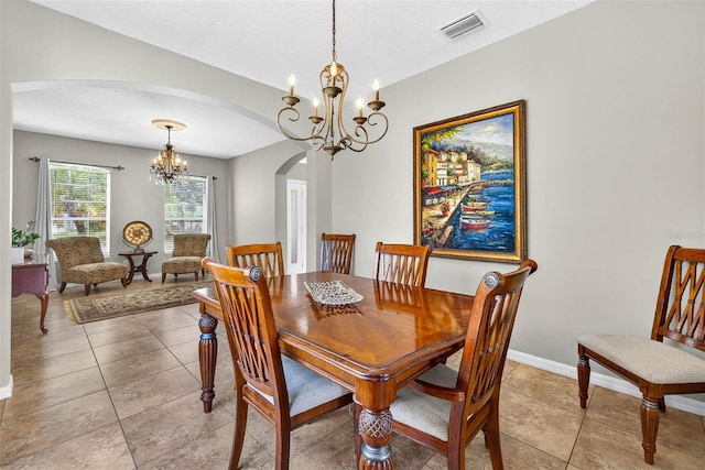 19028 Narimore Dr, Land O Lakes, FL 34638 - dining space featuring a chandelier, arched walkways, and light tile patterned flooring