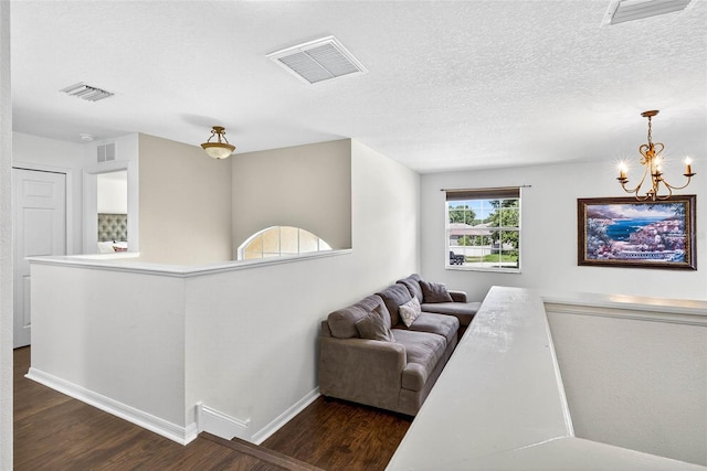 19028 Narimore Dr, Land O Lakes, FL 34638 - living room with dark wood-type flooring, a chandelier, and a textured ceiling