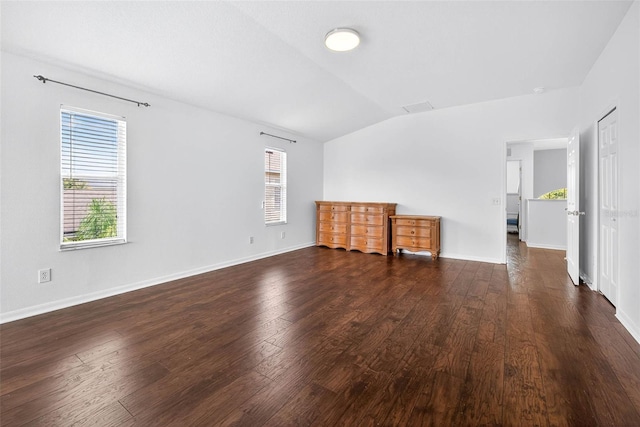 19028 Narimore Dr, Land O Lakes, FL 34638 - unfurnished living room featuring vaulted ceiling, healthy amount of natural light, and dark wood-style flooring