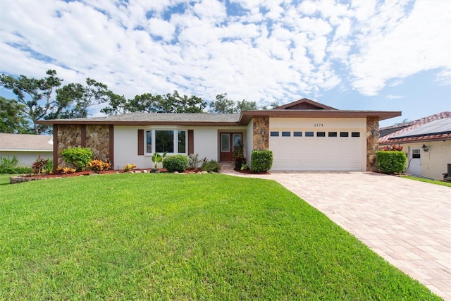 2174 Kent Ave, Clearwater, FL 33764 - single story home featuring stone siding, decorative driveway, a garage, a front yard, and stucco siding