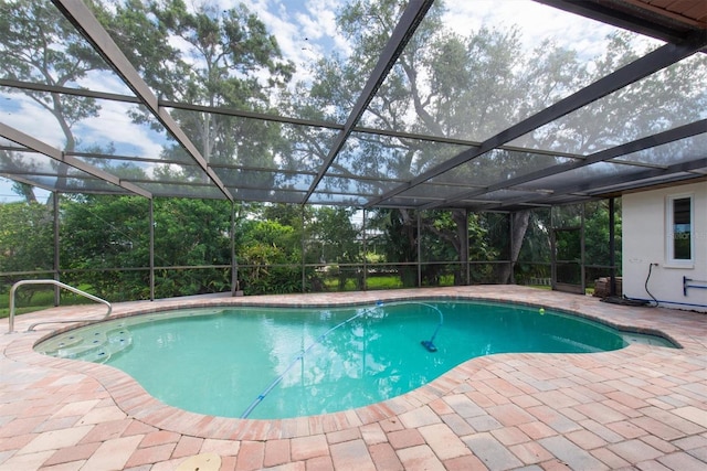 2174 Kent Ave, Clearwater, FL 33764 - outdoor pool with a patio area, glass enclosure, and view of wooded area