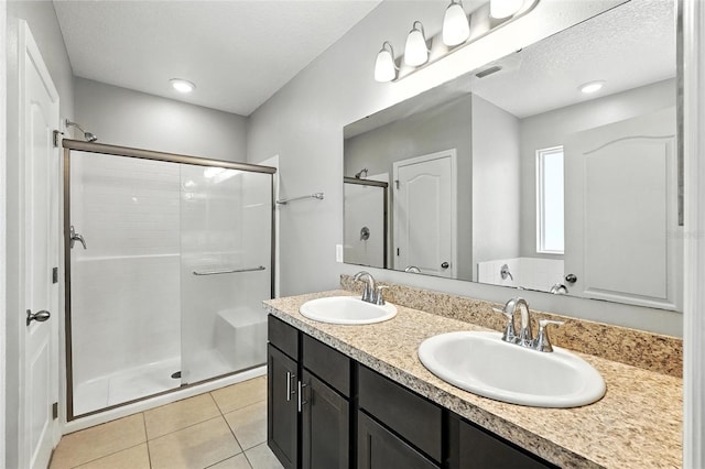 303 Briarbrook Ln, Haines City, FL 33844 - full bathroom with a stall shower, double vanity, tile patterned flooring, and a textured ceiling