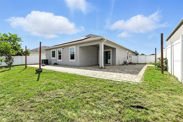 303 Briarbrook Ln, Haines City, FL 33844 - rear view of property with stucco siding, roof mounted solar panels, a fenced backyard, and a patio