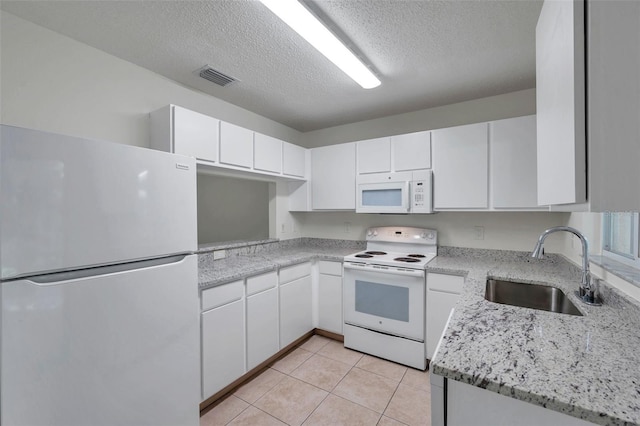 1302 Twilridge Pl, Brandon, FL 33511 - kitchen with white appliances, white cabinetry, a textured ceiling, light tile patterned floors, and light stone counters
