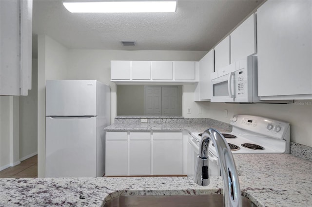 1302 Twilridge Pl, Brandon, FL 33511 - kitchen with white appliances, white cabinetry, tile patterned floors, and a textured ceiling