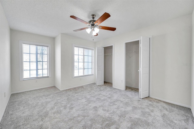 1302 Twilridge Pl, Brandon, FL 33511 - unfurnished bedroom featuring two closets, carpet floors, a textured ceiling, and a ceiling fan