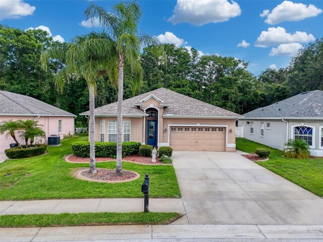 12200 Hunters Lake Dr, New Port Richey, FL 34654 - ranch-style house with stucco siding, a garage, a front yard, and concrete driveway