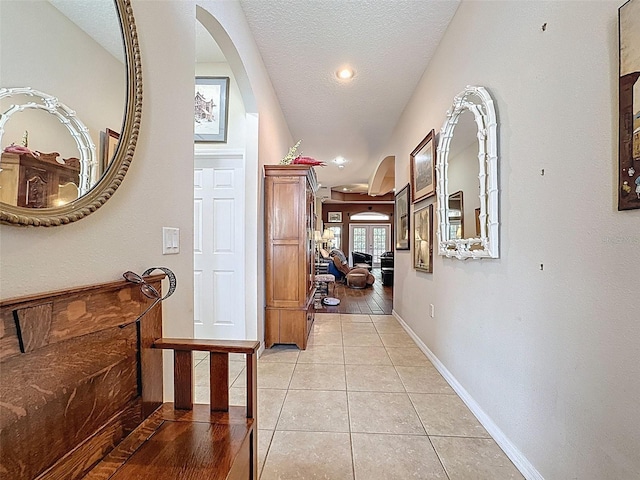 12200 Hunters Lake Dr, New Port Richey, FL 34654 - hallway featuring arched walkways, light tile patterned floors, a textured ceiling, and recessed lighting