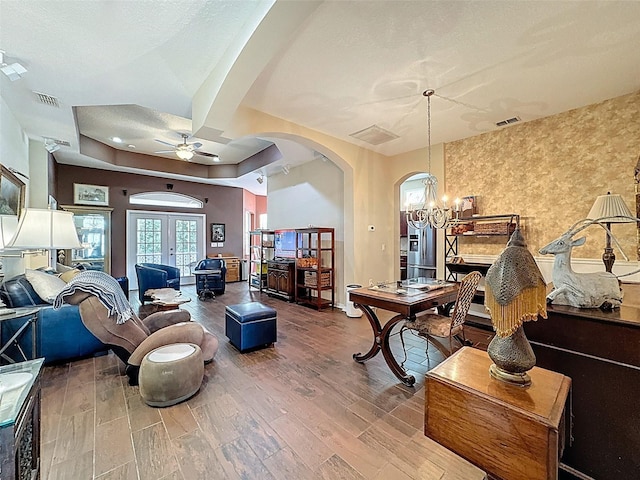 12200 Hunters Lake Dr, New Port Richey, FL 34654 - living room with arched walkways, ceiling fan, a chandelier, wood finished floors, and a tray ceiling