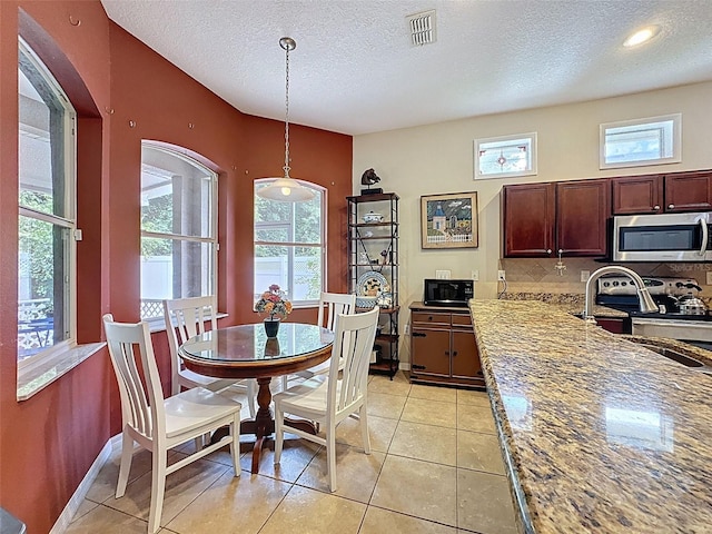 12200 Hunters Lake Dr, New Port Richey, FL 34654 - dining area with a textured ceiling and light tile patterned floors