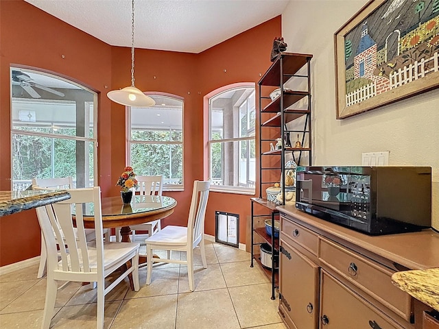 12200 Hunters Lake Dr, New Port Richey, FL 34654 - dining space featuring light tile patterned floors, a ceiling fan, a textured ceiling, and arched walkways