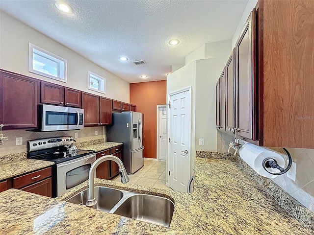 12200 Hunters Lake Dr, New Port Richey, FL 34654 - kitchen with appliances with stainless steel finishes, reddish brown cabinets, tasteful backsplash, recessed lighting, and a textured ceiling