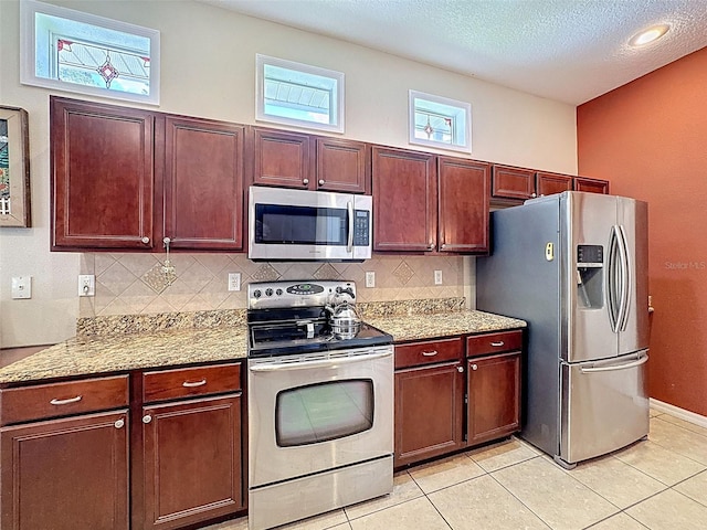 12200 Hunters Lake Dr, New Port Richey, FL 34654 - kitchen with stainless steel appliances, backsplash, a textured ceiling, and light tile patterned flooring