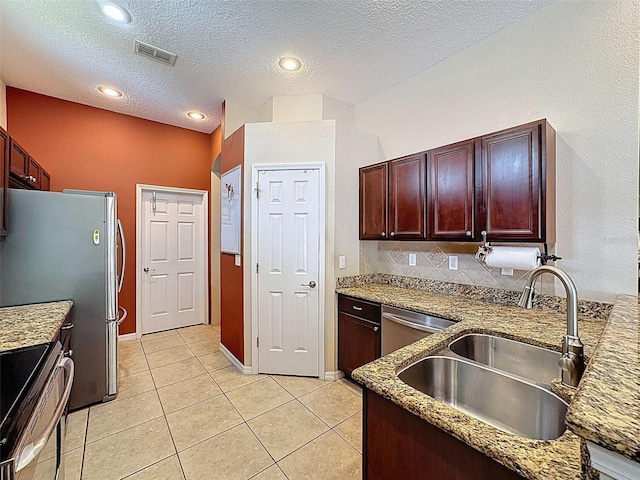 12200 Hunters Lake Dr, New Port Richey, FL 34654 - kitchen featuring stainless steel appliances, light tile patterned floors, light stone counters, a textured ceiling, and decorative backsplash