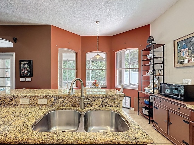 12200 Hunters Lake Dr, New Port Richey, FL 34654 - kitchen with decorative light fixtures, black microwave, light tile patterned flooring, a textured ceiling, and light stone counters
