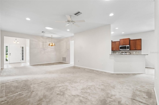 11144 Paradise Point Way, New Port Richey, FL 34654 - unfurnished living room with a chandelier, light colored carpet, ceiling fan, and recessed lighting
