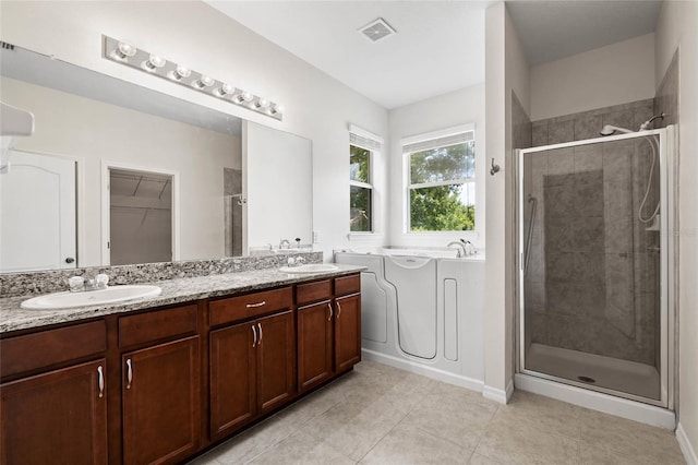 11144 Paradise Point Way, New Port Richey, FL 34654 - full bathroom featuring a shower stall, double vanity, a bath, and tile patterned flooring